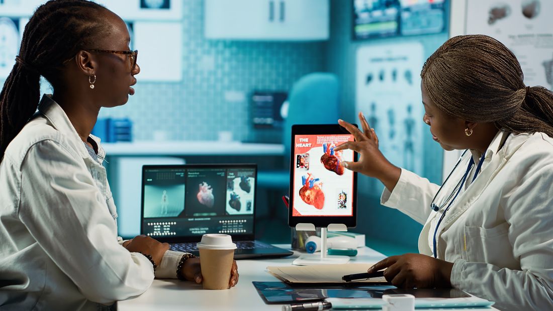 Une médecin présente des images médicales sur une tablette à sa collègue